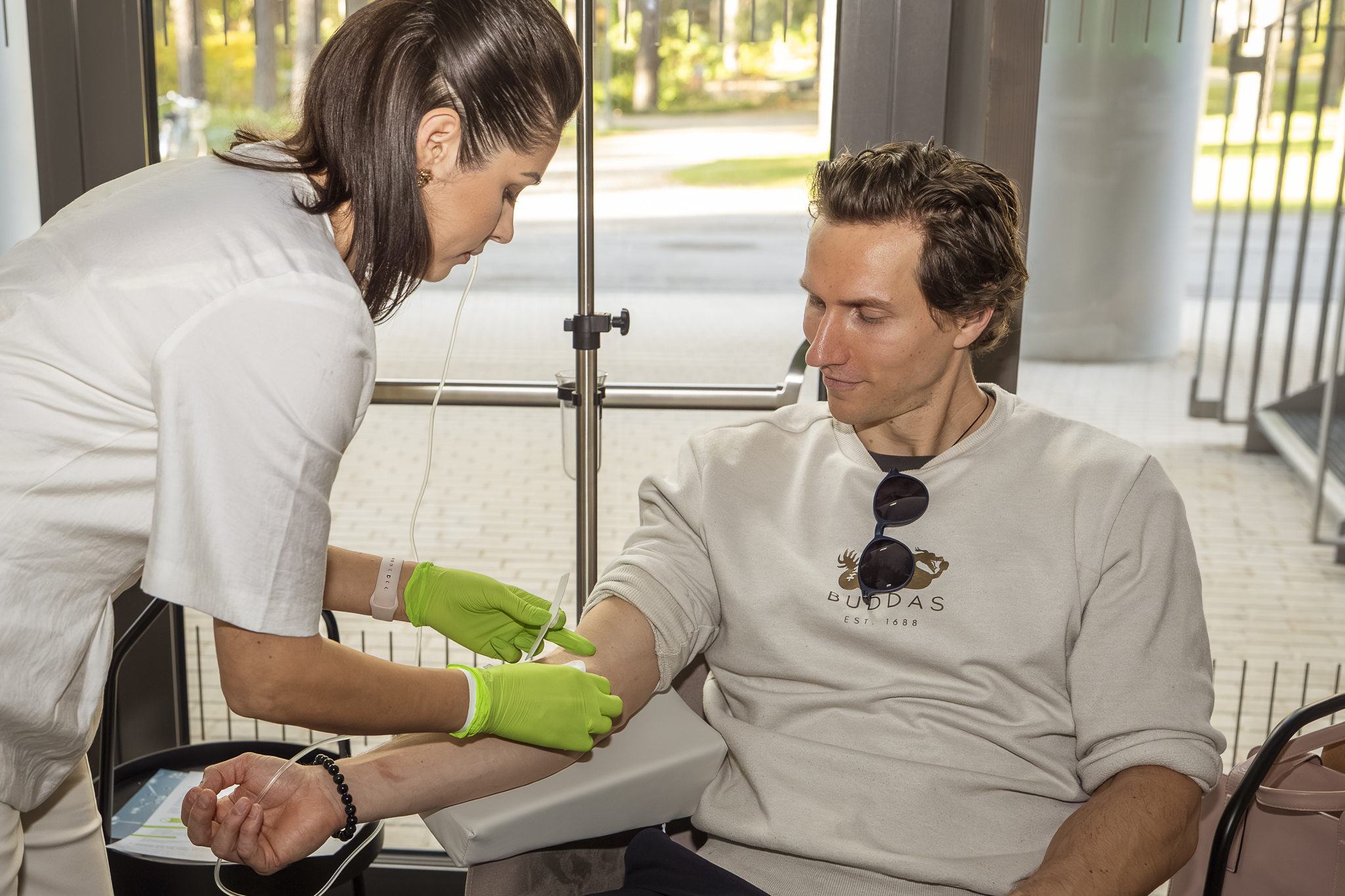 Medmāsa ievieto infūzijas adatu pacienta rokā intravenozas procedūras laikā