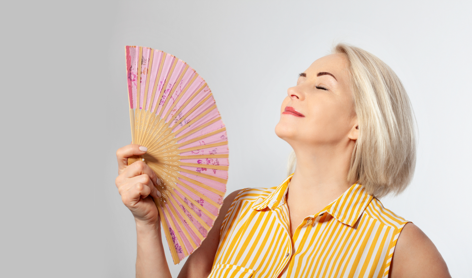 Sieviete ar vēdekli_ilustratīvs foto rakstam par menopauzi