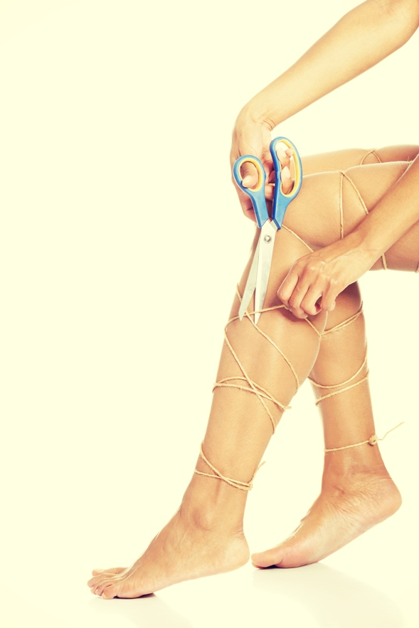 Sievietes kājas apvītas ar virvi, simbolizējot smaguma sajūtu un vēnu problēmas; rokās šķēres, kas gatavas to pārgriezt